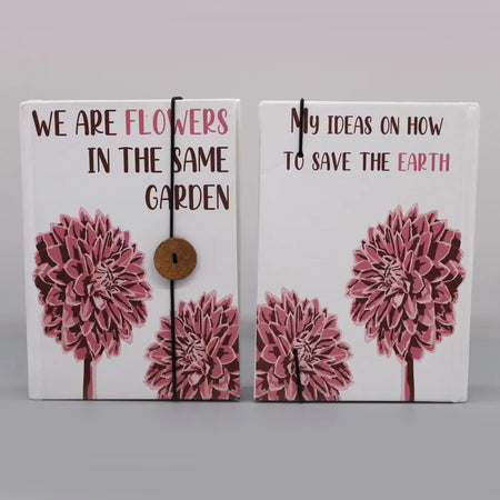 Two white canvas notebooks with pink and brown floral designs and straps with wooden buttons titled flowers in the same garden