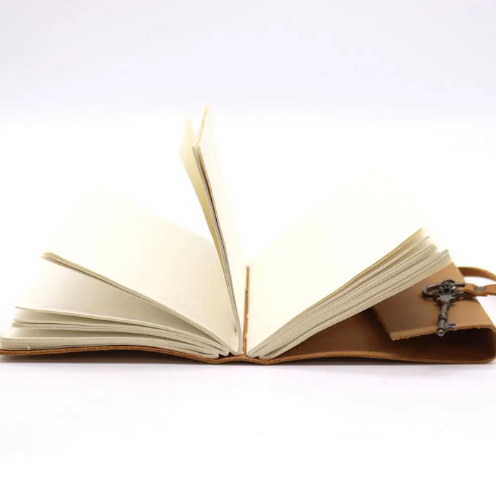 Brown oiled tan leather journal with cream pages and decorative key attached to the cover 7 by 5 inches