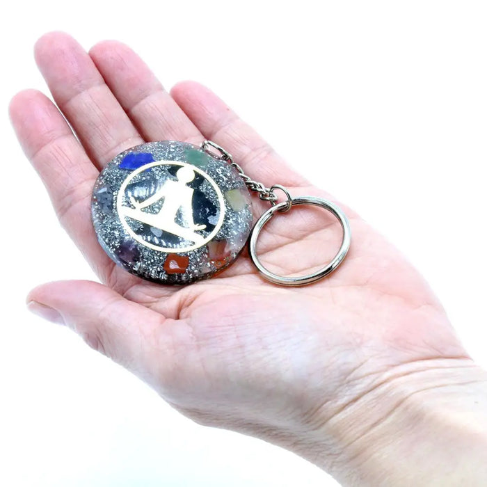 A circular orgonite power keyring with silver metal ring and resin design containing colorful chakra gemstones