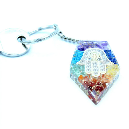 A hexagonal orgonite power keyring with a silver hamsa hand and colorful multi-toned crystal resin fragments