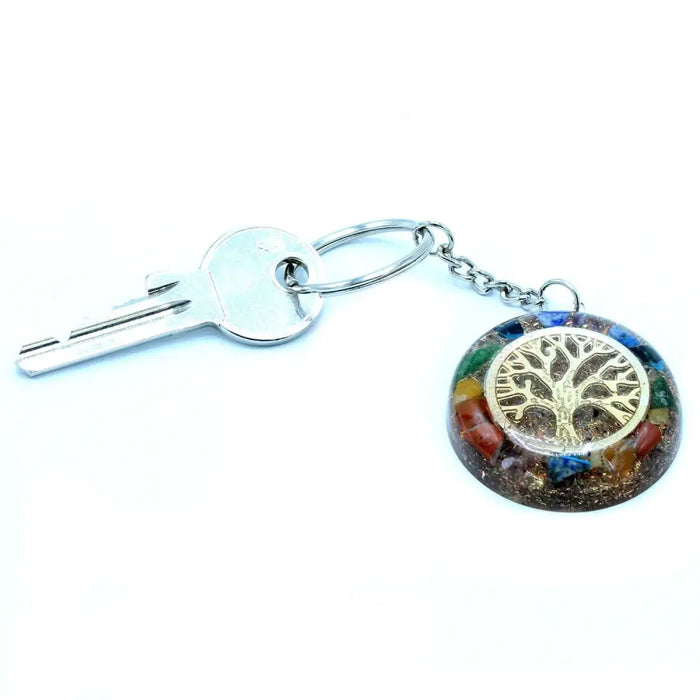 A circular multi-colored resin orgonite power keyring with a golden tree of life design and gemstones chakra details