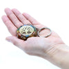 A round multicolored resin orgonite power keyring with a golden tree of life design and embedded gemstones