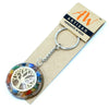 A circular multicolored resin orgonite power keyring with a golden tree of life embedded in its translucent surface