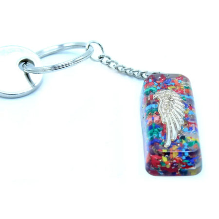 A silver angel wing charm in a multicolored resin orgonite power keyring with a metal chain and ring for guardian protection