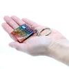 A colorful rectangular resin orgonite power keyring with embedded gemstones and gold spiral designs for home protection