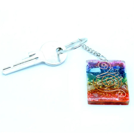 A square rainbow resin orgonite power keyring with copper wire swirls glitter and a silver metal chain for home protection