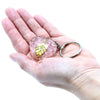 A translucent pink orgonite power keyring heart with a golden leaf inside attached to a silver metal ring