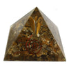 A 5cm clear resin orgonite pyramid with golden tiger eye stones red spiral wire and metallic flakes inside