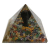 A clear 5cm orgonite pyramid with colorful gemstones and a black angel figurine inside made of resin