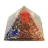 A 5cm clear resin orgonite pyramid with red blue orange gemstones and copper wire coils featuring ganesh design
