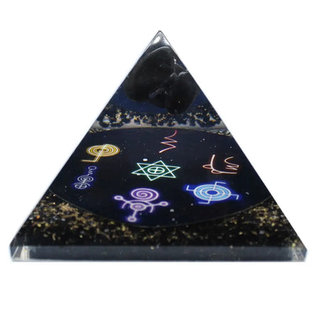 A large sleek black resin orgonite pyramid with glowing symbols golden glitter and a dark stone on top
