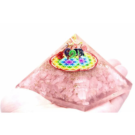 Orgonite pyramid made of translucent pink rose quartz with golden glitter and a colorful rainbow flower of life design at the top