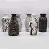 Black and white ceramic vases with bamboo motif and intricate carved patterns in natural finish