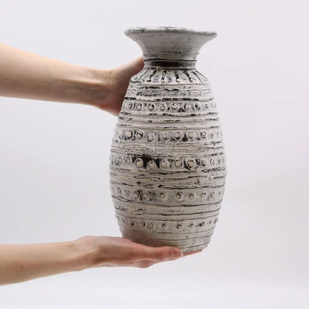 Ornamental shaped ceramic vase cream with textured gray surface and raised circular bands and flared rim