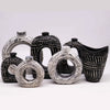Black and white ornamental ceramic vases with swirled textured surfaces in a chocolate brown setting