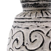 A white ceramic ornamental vase with black hand-painted swirling and linear patterns in a cream setting