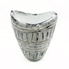 A distressed silver-toned ceramic vase with a wide neck, curved top, vertical ridges, and circular studs in cream tones