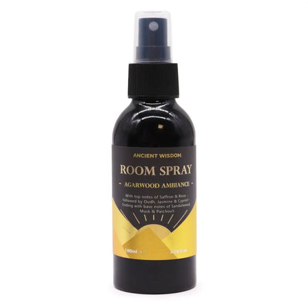 A sleek black glass oudh room spray bottle with matte black nozzle labeled agarwood ambiance in gold and yellow design