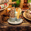 Gray ceramic smudge holder with two compartments holding sage bundles and a palo santo stick with lotus flower design