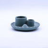 A matte teal ceramic palo santo stick and smudge holder with two cylindrical holders on a scalloped lotus flower base