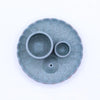 A blue speckled teal ceramic palo santo stick and smudge holder with scalloped edges and two circular bowls