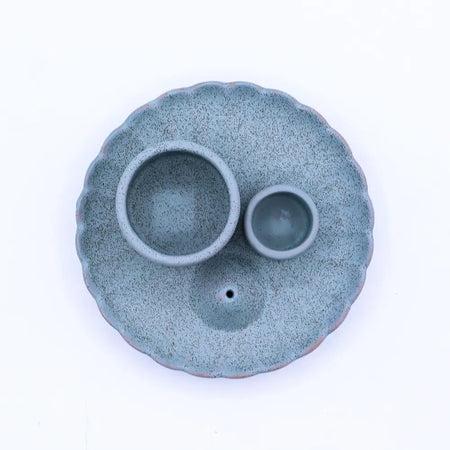 A blue speckled teal ceramic palo santo stick and smudge holder with scalloped edges and two circular bowls