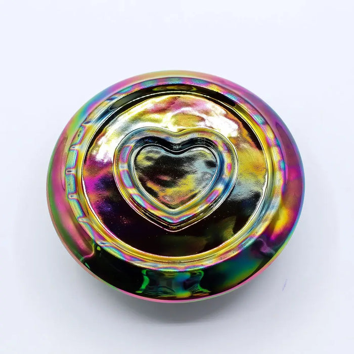 A metallic rainbow palo santo stick and smudge holder with a round iridescent fidget spinner design and heart center