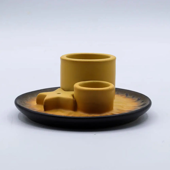 Yellow ceramic smudge holder set with star centerpiece on black plate for palo santo sticks and sage bundles