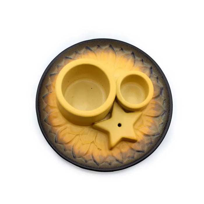 Yellow ceramic pet feeding station with two bowls and star divider on sunflower base next to palo santo sticks smudge holder