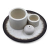 Set of three white ceramic palo santo stick and smudge holder pieces on a black and white speckled plate for sage bundles
