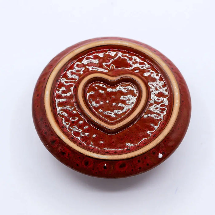 Red ceramic smudge holder with heart indentation and speckled glaze for palo santo sticks and sage bundles