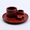 Red ceramic palo santo stick and smudge holder set with glossy finish and two cylindrical holders on matching saucer