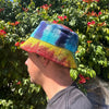 A vibrant tie-dye cotton boho festival hat with patched hemp and cotton woven fabric in blue teal yellow and red