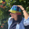 A vibrant tie-dye bucket hat in rainbow hues made of patched hemp and cotton boho festival fabric