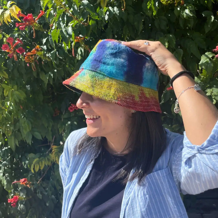 A vibrant tie-dye bucket hat in rainbow hues made of patched hemp and cotton boho festival fabric