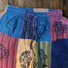 Patchwork trousers in orange with multicolored panels featuring black mushroom and floral patterns in size S/M