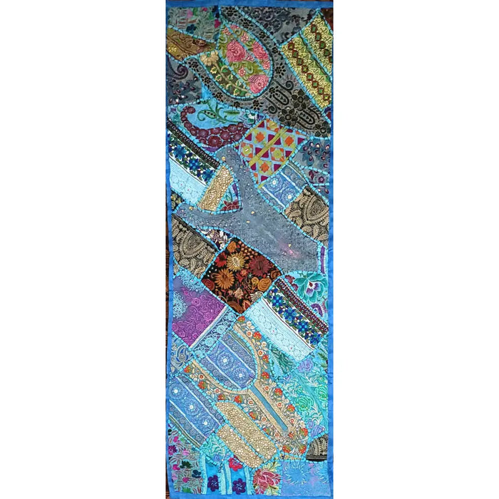 A patchwork wall hanging and table runner with blue, turquoise, gold, purple, and brown paisley and floral patterns