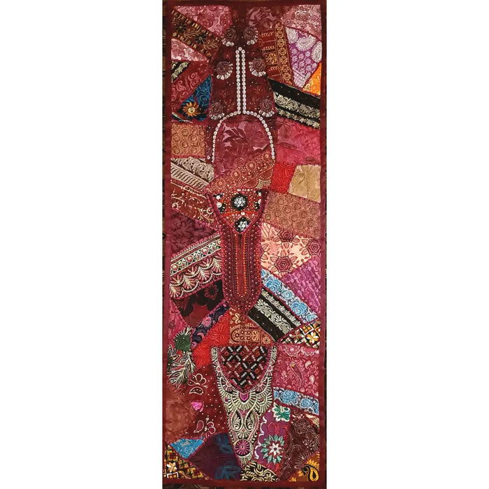 A patchwork wall hanging and table runner with an embroidered guitar in reds pinks golds and purples