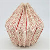 A cream origami light shade with red geometric patterns folded into a hexagonal shape for a short pendant light