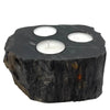 Dark rustic petrified wood tealight holder with three circular indentations holding white candles