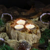Petrified wood tealight holder with three lit candles in a rustic textured natural stone wood tealight design