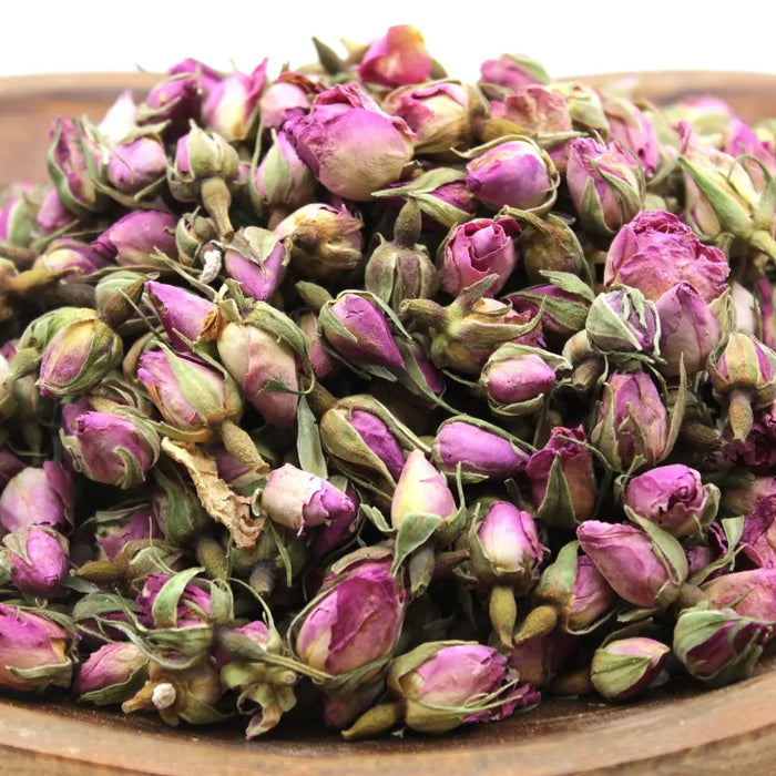 A wooden bowl filled with dried pink rose buds showing purple and green hues weighing 0.5kg