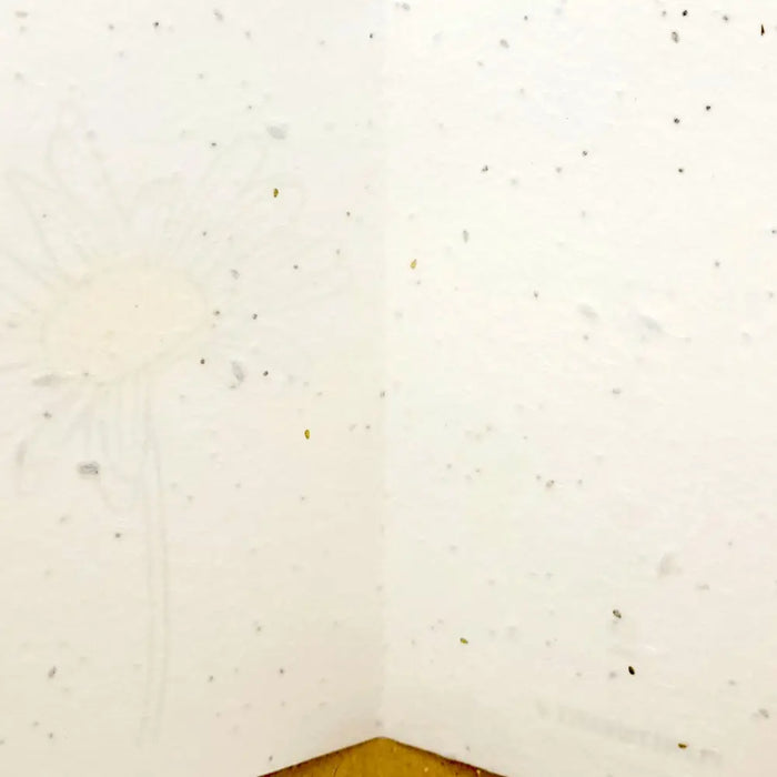 White plantable greetings card with subtle floral pattern made from daisy seed paper and paired with kraft envelope