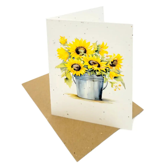 A white sunflower seed paper greetings card with yellow sunflowers in a metallic silver bucket illustration
