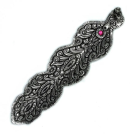 Silver-toned ornate hair clip with pink gemstone shown beside polished aluminium incense holder buddha long design