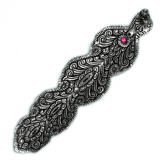 Silver-toned ornate hair clip with pink gemstone shown beside polished aluminium incense holder buddha long design