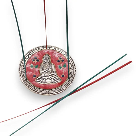 Red and silver polished aluminium incense holder with buddha design enameled details and green and red incense sticks hanging