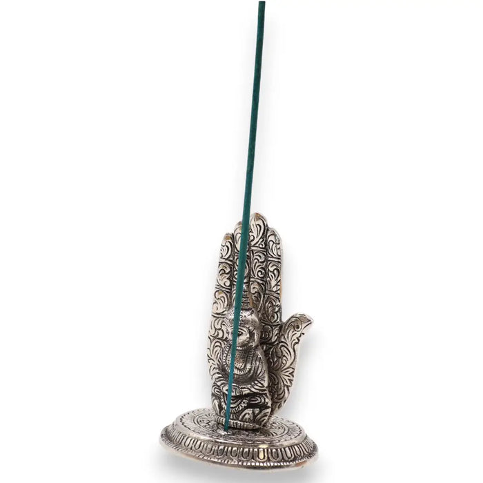 Silver polished aluminium incense holder shaped like a hamsa hand with filigree and a green incense stick upright