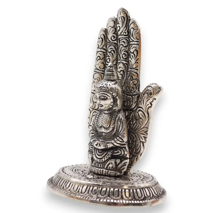 Silver-colored polished aluminium incense holder with buddha figurine seated inside an ornately carved hand