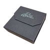 Dark gray textured gift box with teal pure attraction flap holding a polished gold-tone heart pendant necklace